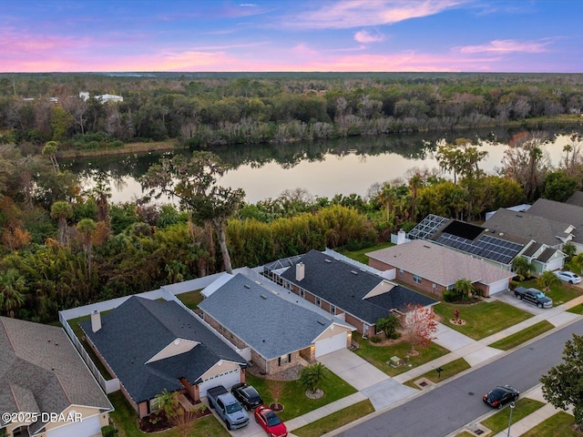 aerial view at dusk featuring a water view