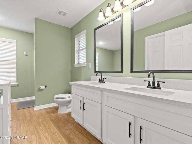 bathroom featuring wood-type flooring, vanity, and toilet