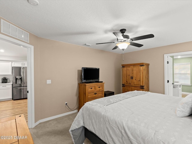 carpeted bedroom with ceiling fan, stainless steel fridge with ice dispenser, and a textured ceiling