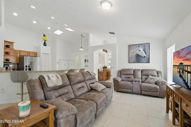3348 Heath Dr, Deltona, FL 32725 - living room with lofted ceiling, arched walkways, light tile patterned floors, recessed lighting, and a skylight