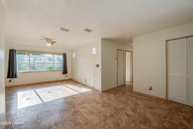 spare room with a textured ceiling and ceiling fan