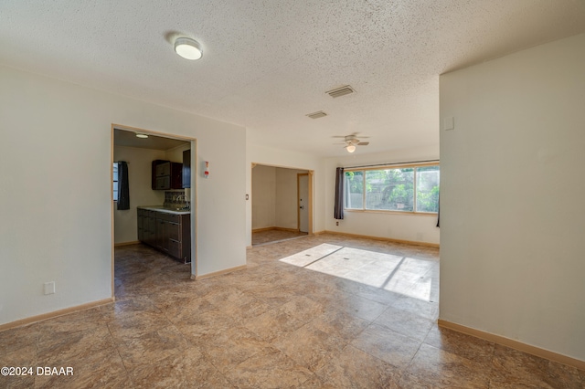 empty room featuring ceiling fan and a textured ceiling