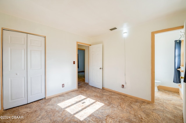 unfurnished bedroom featuring ensuite bath and a closet