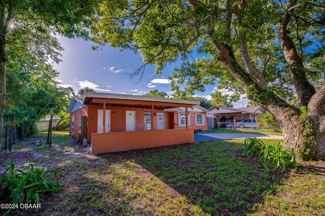 back of property with a lawn and a patio area