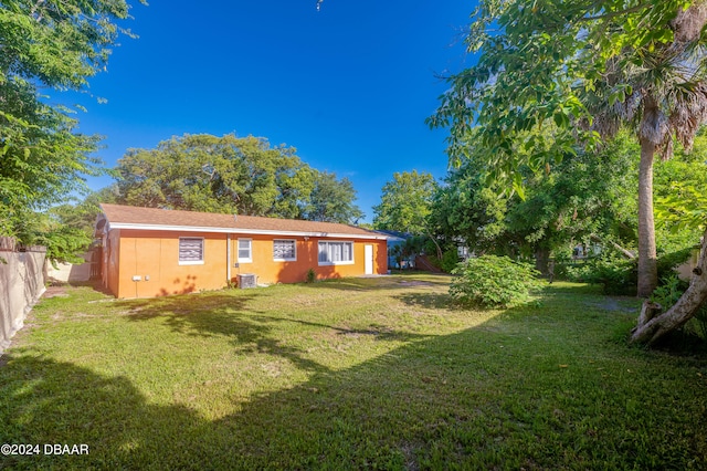 exterior space with central AC unit and a lawn