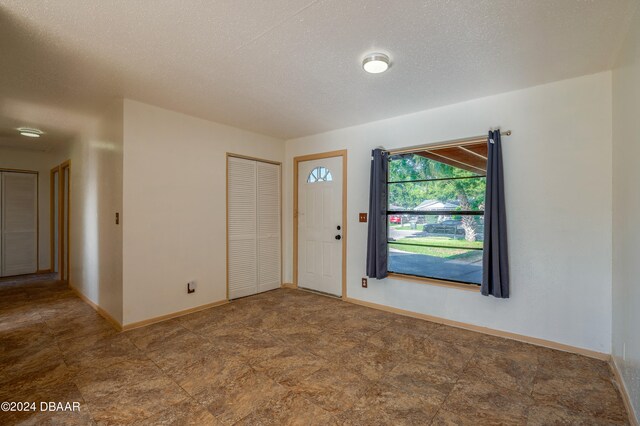 unfurnished room featuring a textured ceiling