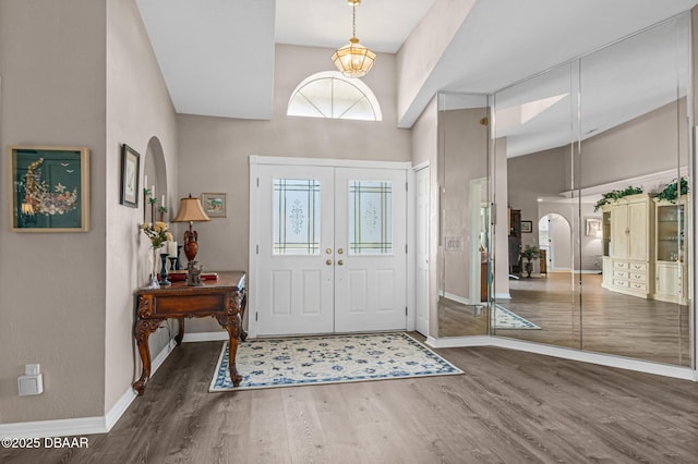 entryway with french doors, dark hardwood / wood-style floors, and a towering ceiling