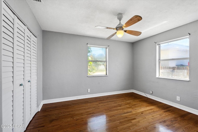 unfurnished bedroom with hardwood / wood-style floors, ceiling fan, a textured ceiling, and a closet