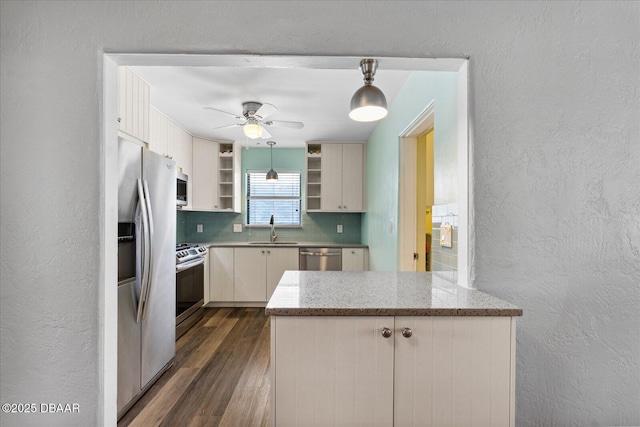 kitchen featuring white cabinetry, sink, stainless steel appliances, pendant lighting, and decorative backsplash