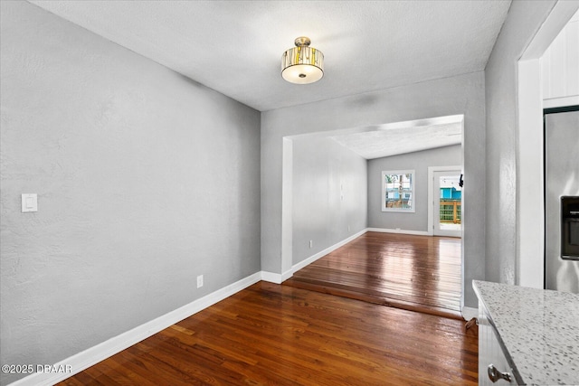 unfurnished living room with dark hardwood / wood-style flooring and vaulted ceiling