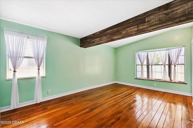 spare room featuring hardwood / wood-style flooring and beamed ceiling