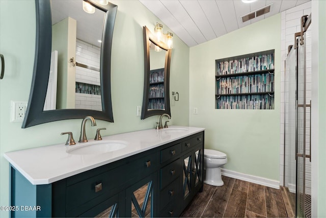 bathroom featuring vanity, toilet, and a shower