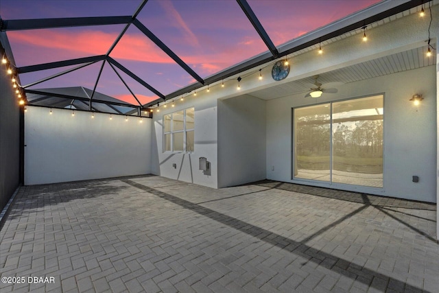 patio terrace at dusk with a lanai and ceiling fan