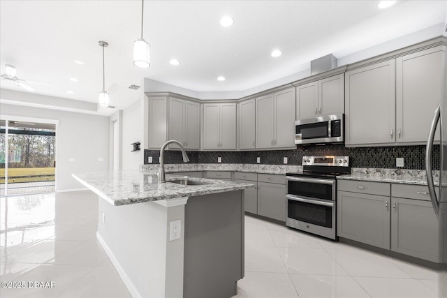 kitchen with appliances with stainless steel finishes, sink, hanging light fixtures, and gray cabinetry