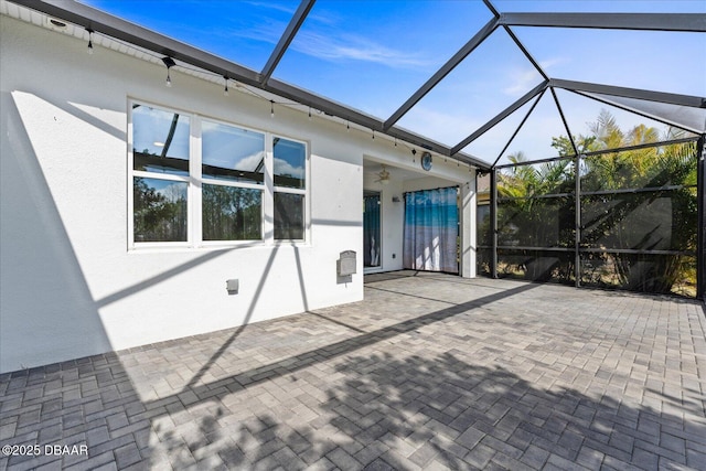 view of patio / terrace with ceiling fan and glass enclosure