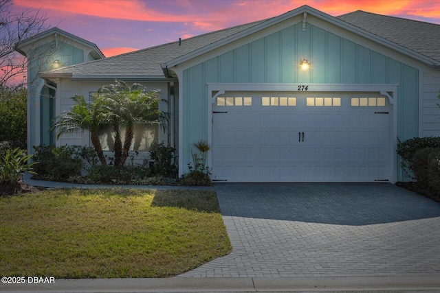 view of front of property with a garage and a lawn