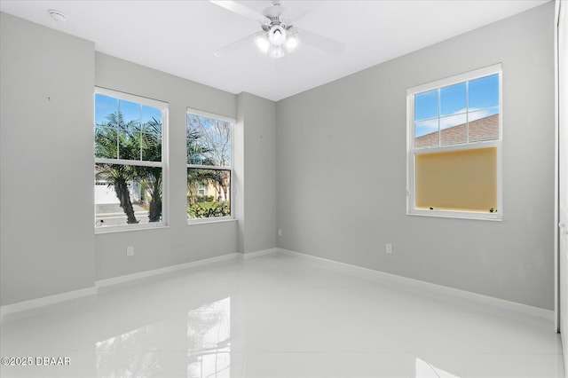 tiled spare room featuring ceiling fan