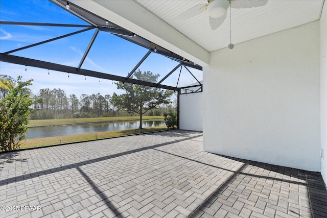 view of patio / terrace with a water view, ceiling fan, and glass enclosure