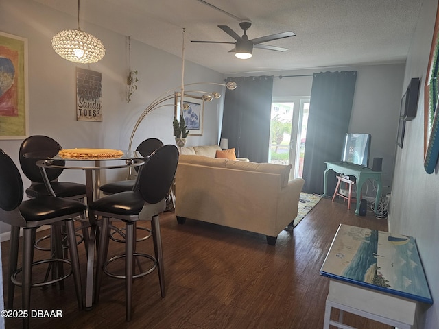 living room with ceiling fan, dark hardwood / wood-style floors, and a textured ceiling