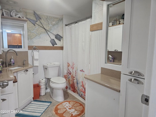 bathroom featuring tile patterned flooring, vanity, curtained shower, and toilet