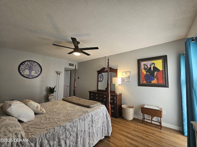 bedroom featuring hardwood / wood-style floors, a textured ceiling, and ceiling fan