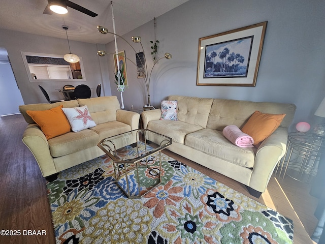 living room with dark wood-type flooring and ceiling fan