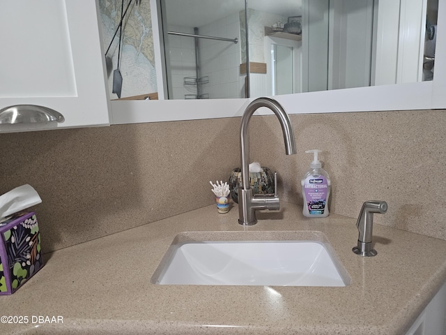 interior details featuring sink, decorative backsplash, and walk in shower