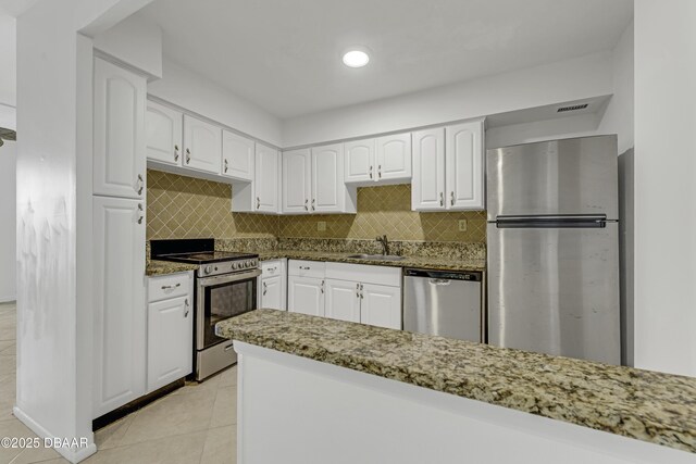 2800 N Atlantic Ave Unit 1712, Daytona Beach, FL 32118 - kitchen featuring appliances with stainless steel finishes, dark stone counters, white cabinetry, and recessed lighting