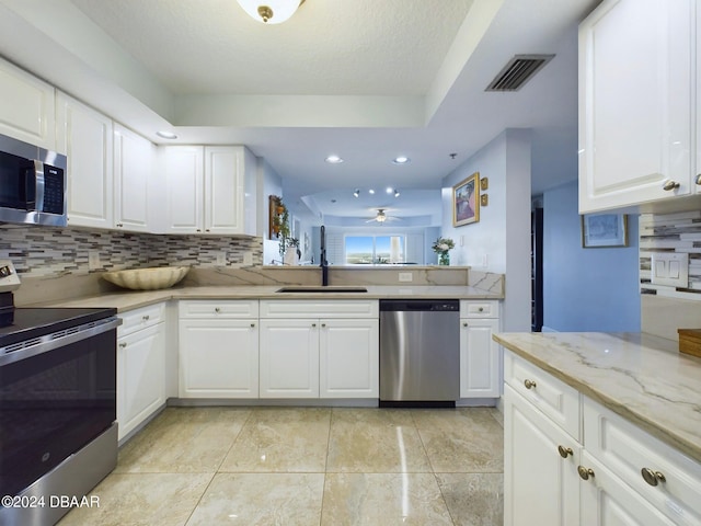 4670 Links Village Dr Unit C601, Ponce Inlet, FL 32127 - kitchen featuring appliances with stainless steel finishes, tasteful backsplash, ceiling fan, white cabinets, and recessed lighting