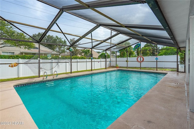 view of pool with glass enclosure and a patio area