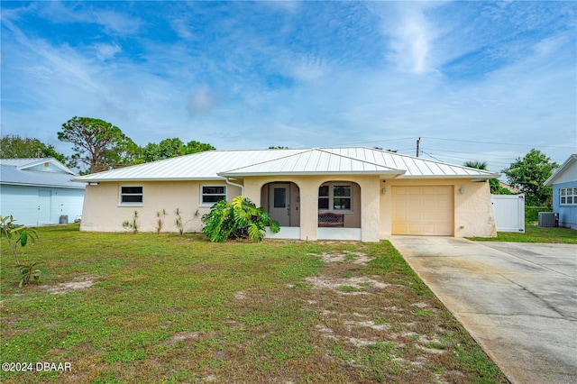 ranch-style house with a garage, central air condition unit, and a front lawn