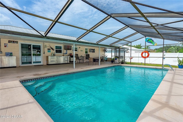 view of pool featuring glass enclosure and a patio