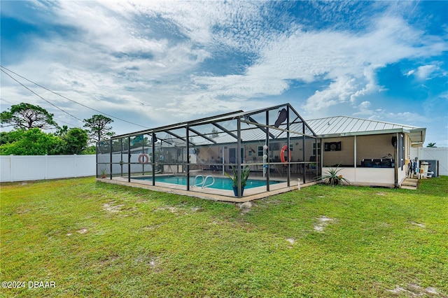 view of pool with a lawn, glass enclosure, and a patio area