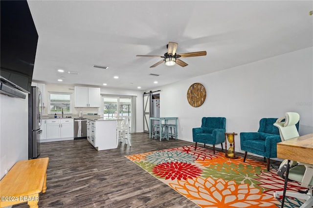 1320 Johns Cir, Merritt Island, FL 32952 - living area featuring a barn door, dark wood-type flooring, a ceiling fan, recessed lighting, and baseboards