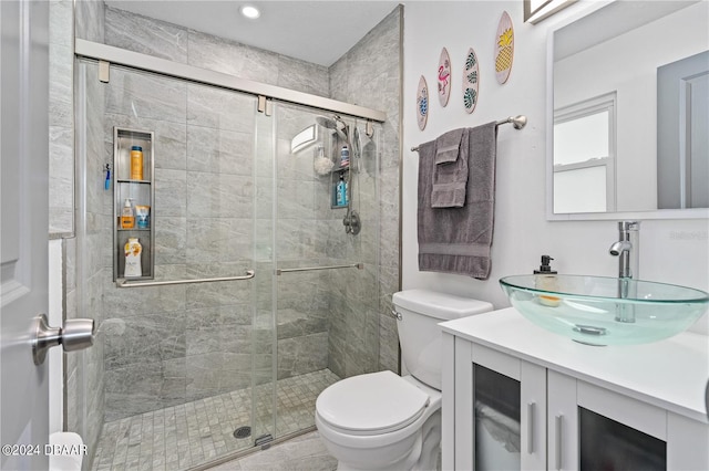 bathroom featuring vanity, toilet, and an enclosed shower