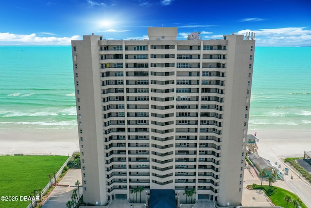 view of building exterior with a water view and a view of the beach