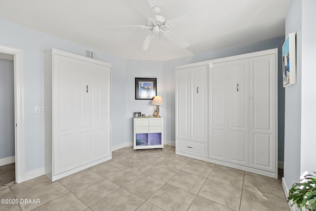 unfurnished bedroom with light tile patterned floors and ceiling fan