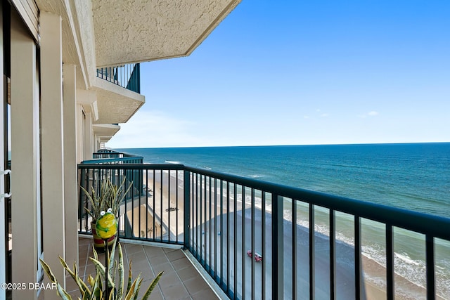 balcony with a water view and a beach view