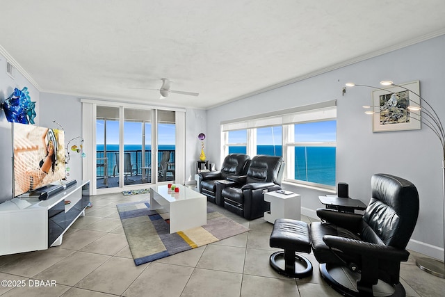 tiled living room with ornamental molding, ceiling fan, and a water view