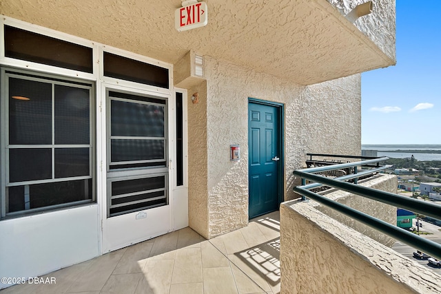 entrance to property with a balcony and a water view