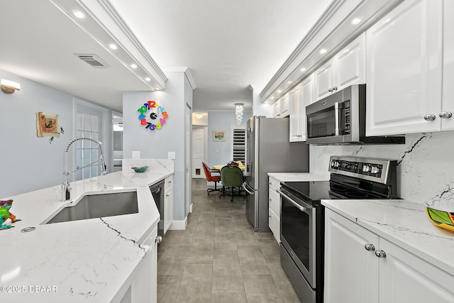 kitchen featuring white cabinetry, appliances with stainless steel finishes, sink, and light stone counters