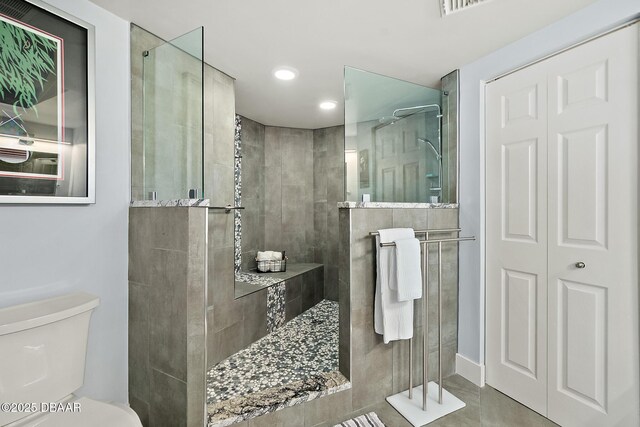 bathroom with toilet and tiled shower