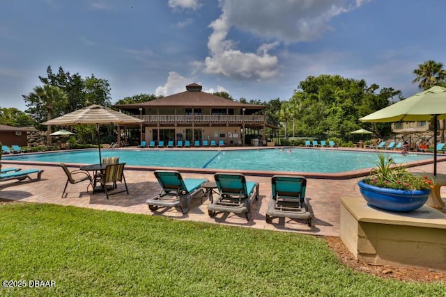 pool with a yard and a patio