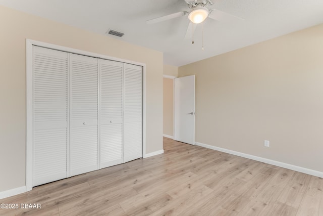 unfurnished bedroom with ceiling fan, light wood-type flooring, and a closet