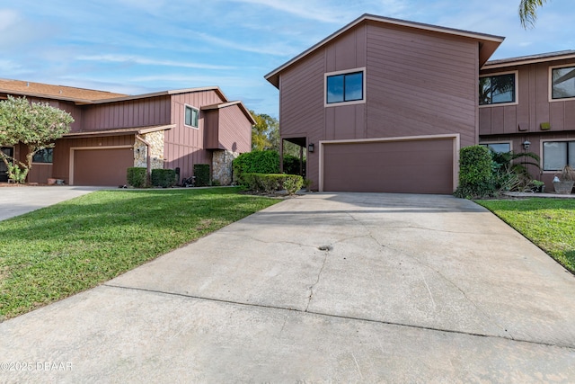 view of front of home with concrete driveway, a front lawn, and an attached garage