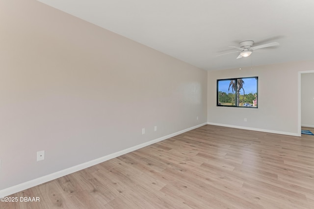 empty room with a ceiling fan, light wood-style flooring, and baseboards