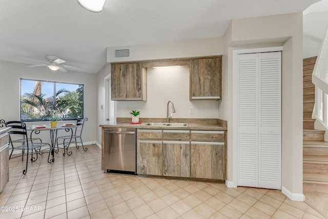 kitchen featuring ceiling fan, stainless steel dishwasher, sink, and light tile patterned floors