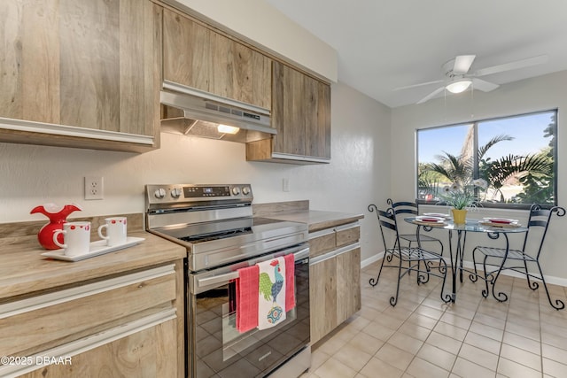 kitchen with baseboards, electric stove, ceiling fan, light countertops, and under cabinet range hood