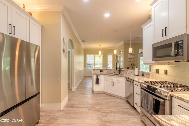 kitchen with stainless steel appliances, sink, light stone countertops, white cabinets, and pendant lighting