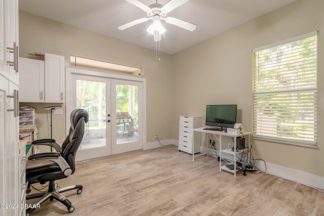 home office with plenty of natural light, light wood-type flooring, and french doors